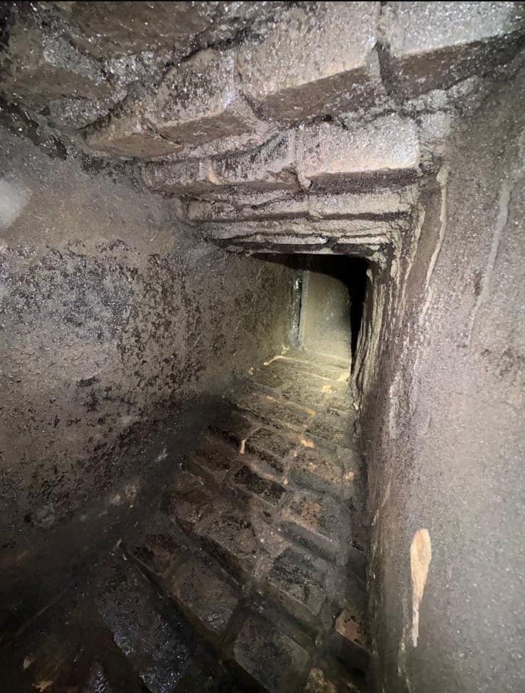 Rough corbelled brick smoke chamber coated in soot before parging