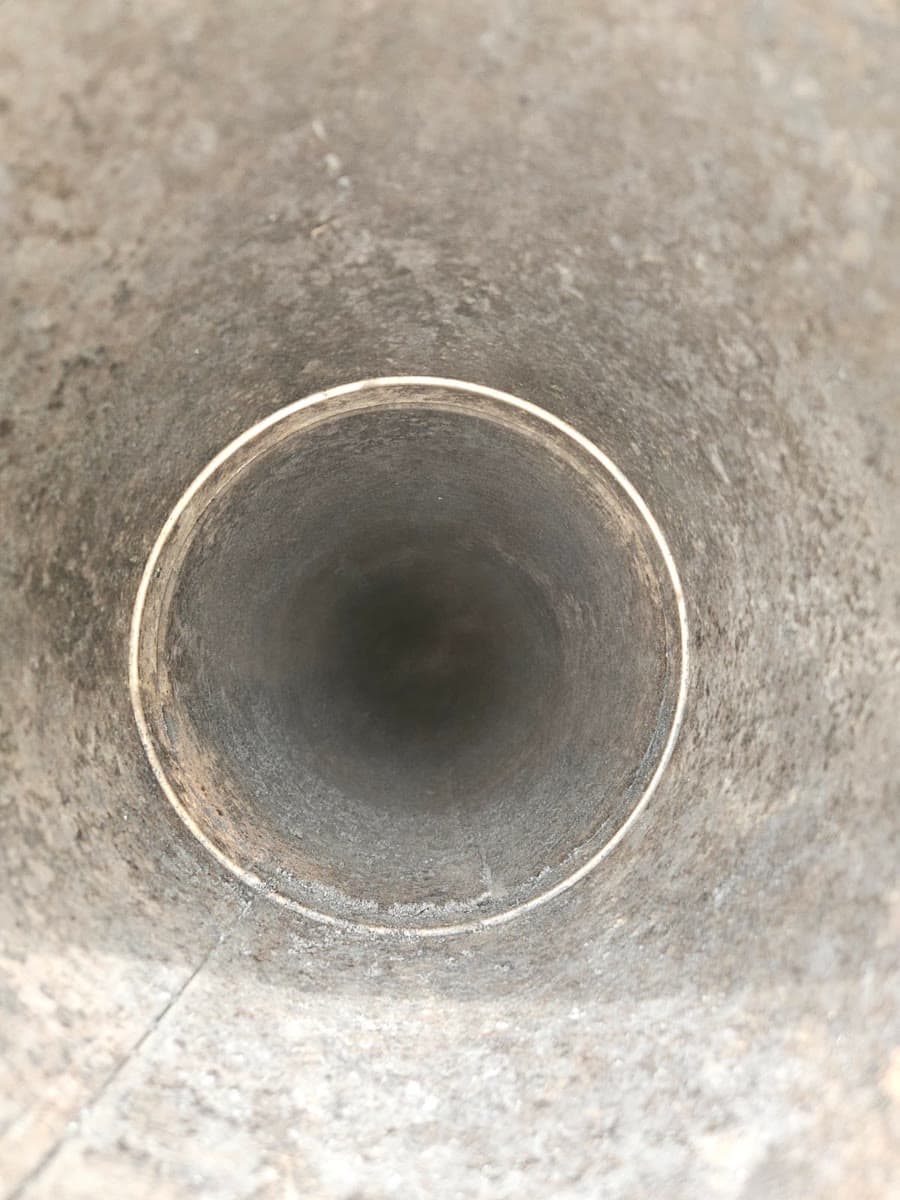 The same round metal flue liner after sweeping, walls brushed clean down to the metal